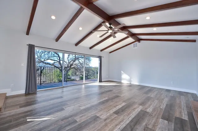 a view of empty room with wooden floor and fireplace