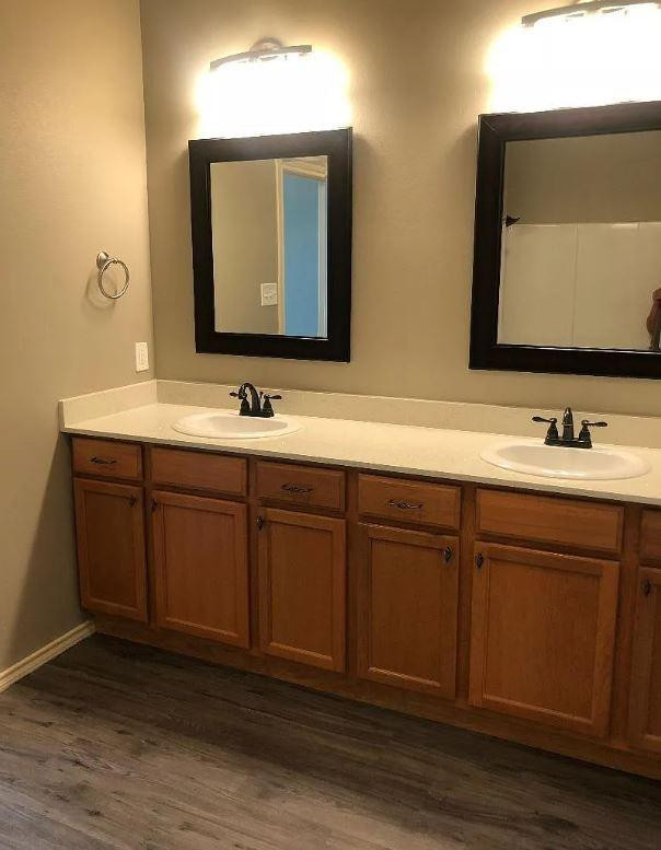 1203 Preston Trail, Unit B Wolfforth, TX 79382 - Photo 11 of 13 a bathroom with a double vanity sink and mirror