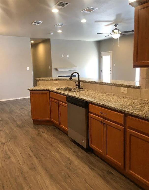 1203 Preston Trail, Unit B Wolfforth, TX 79382 - Photo 6 of 13 a large kitchen with stainless steel appliances granite countertop a sink and a dishwasher with wooden floor