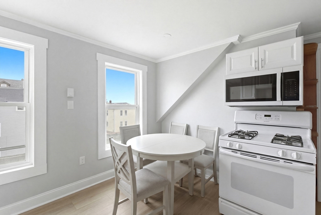 81 Ward Street Worcester, MA 01610 - Photo 14 of 34 a kitchen with stainless steel appliances a white table and chairs