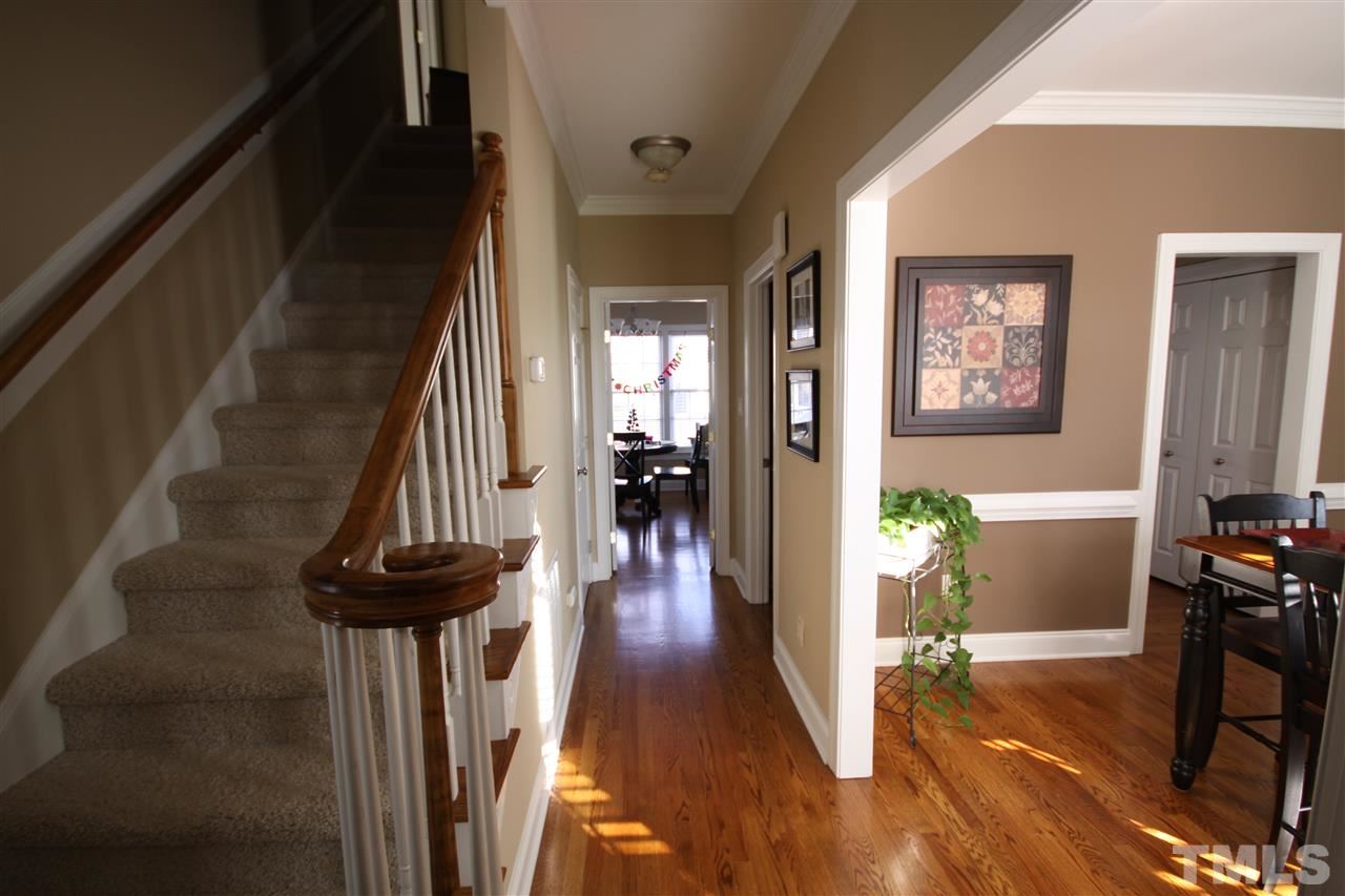 10001 Kilnstone Lane Raleigh, NC 27613 - Photo 3 of 9 a view of a hallway to a livingroom with wooden floor and furniture