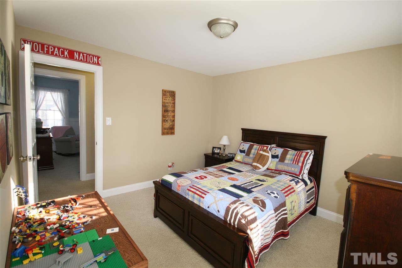 10001 Kilnstone Lane Raleigh, NC 27613 - Photo 7 of 9 a bedroom with a bed and a painting on the wall