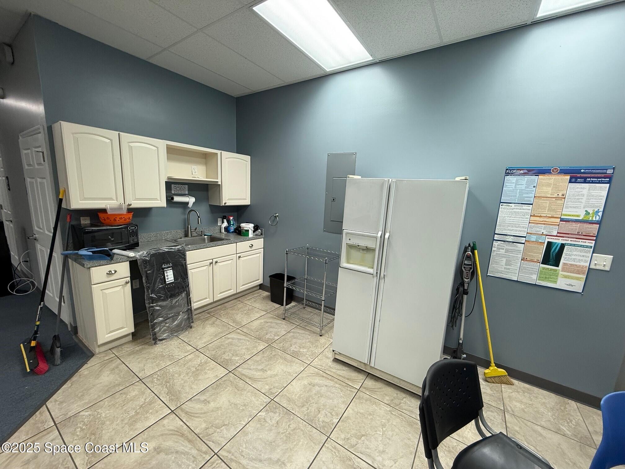 5121 Industry Drive, Unit 103105 Melbourne, FL 32940 - Photo 10 of 13 a kitchen with stainless steel appliances a stove a refrigerator and a sink