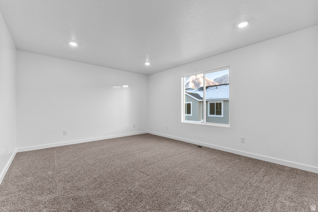 2829 North 710 West, Unit 15 Logan, UT 84321 - Photo 16 of 23 Spacious room featuring neutral carpet flooring, white walls, recessed ceiling lighting, and a window providing natural light