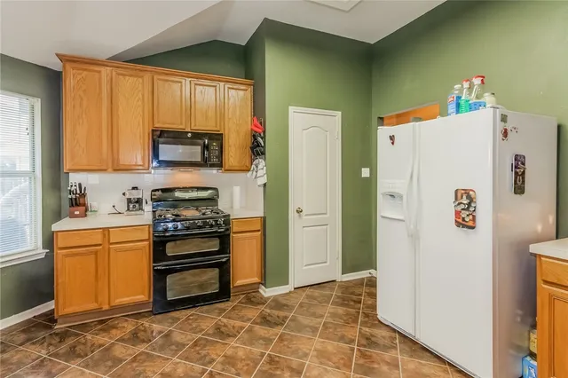 a kitchen with stainless steel appliances a refrigerator and a stove top oven