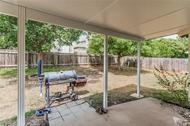 a view of a patio with table and chairs with wooden fence and floor