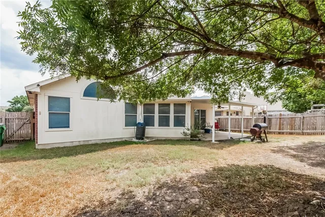 a view of a house with backyard and sitting area