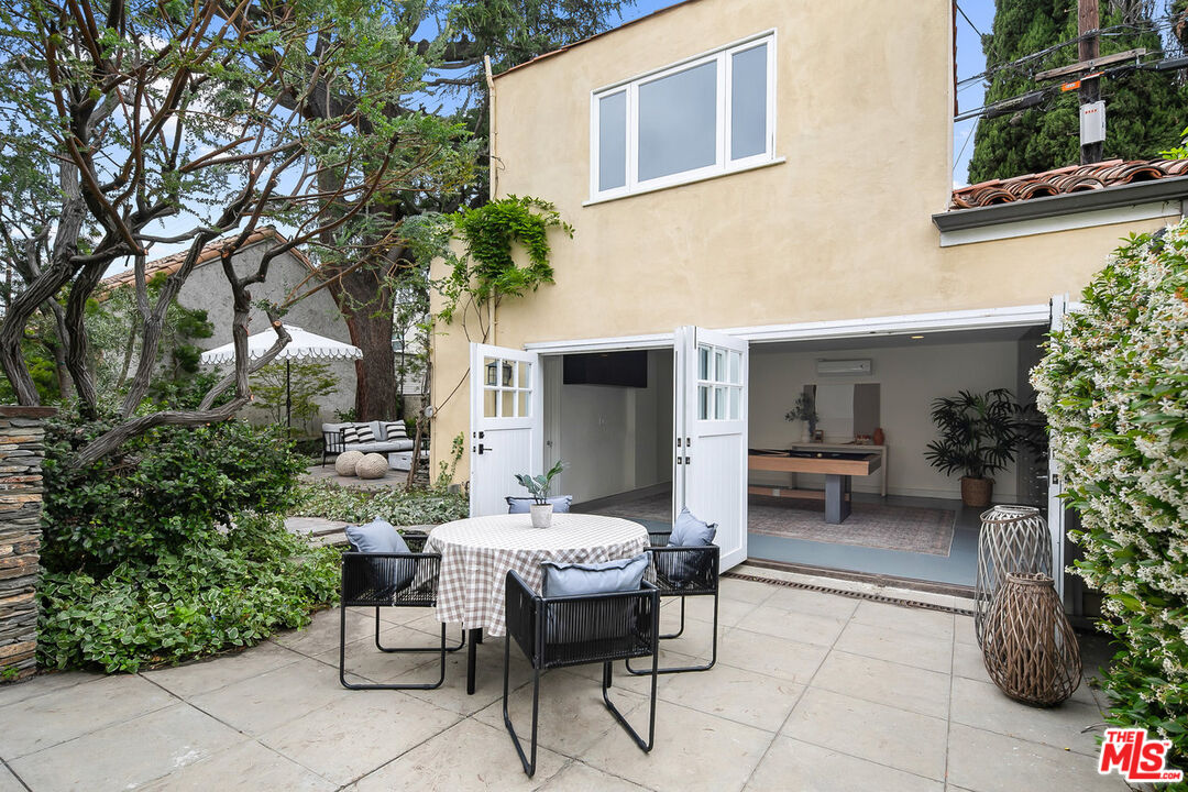 232 North Windsor Boulevard Los Angeles, CA 90004 - Photo 14 of 20 a view of a patio with table and chairs potted plants and large tree