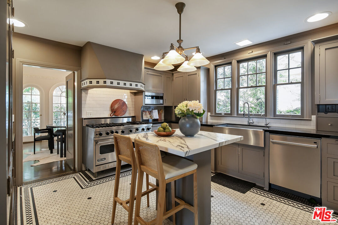 232 North Windsor Boulevard Los Angeles, CA 90004 - Photo 5 of 20 a kitchen with stainless steel appliances granite countertop a sink a stove and a refrigerator