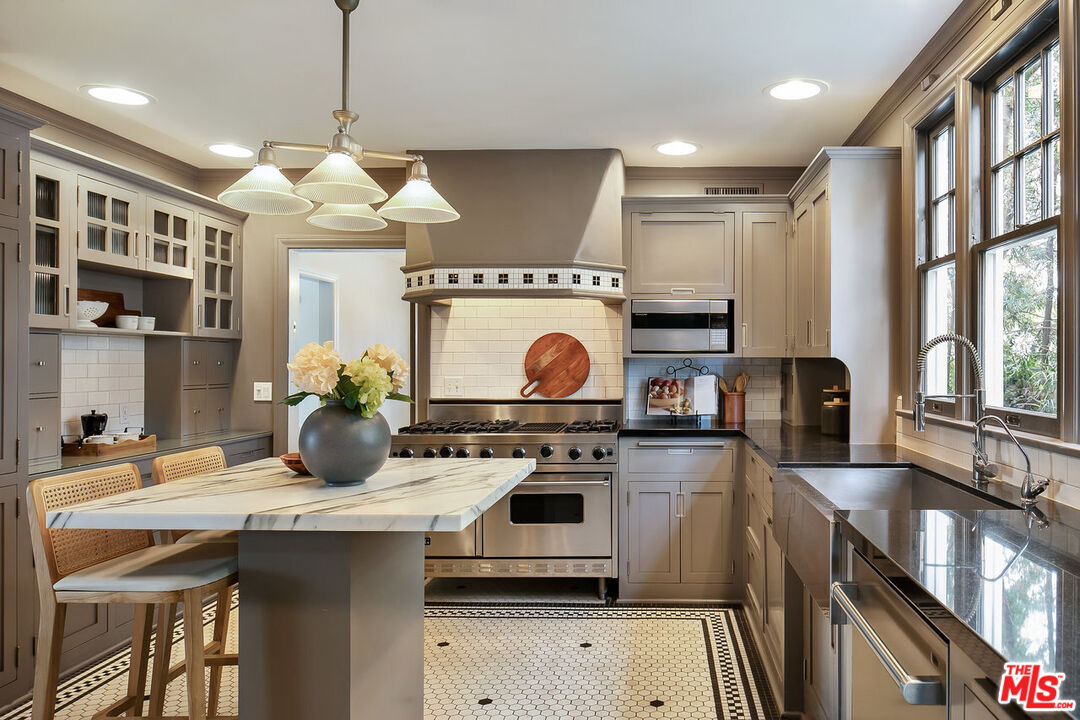 232 North Windsor Boulevard Los Angeles, CA 90004 - Photo 6 of 20 a kitchen with stainless steel appliances a stove a sink and a refrigerator