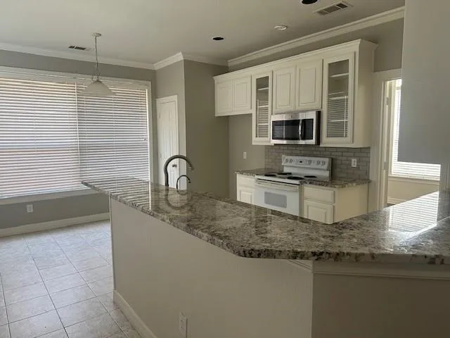 a kitchen with kitchen island granite countertop a sink and a stove top oven