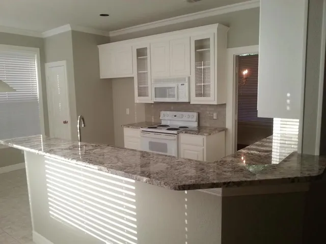 a kitchen with granite countertop a sink and a stove