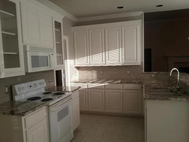 a kitchen with stainless steel appliances granite countertop a sink stove and cabinets