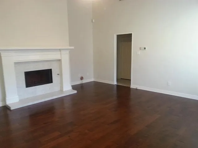 an empty room with wooden floor and fireplace