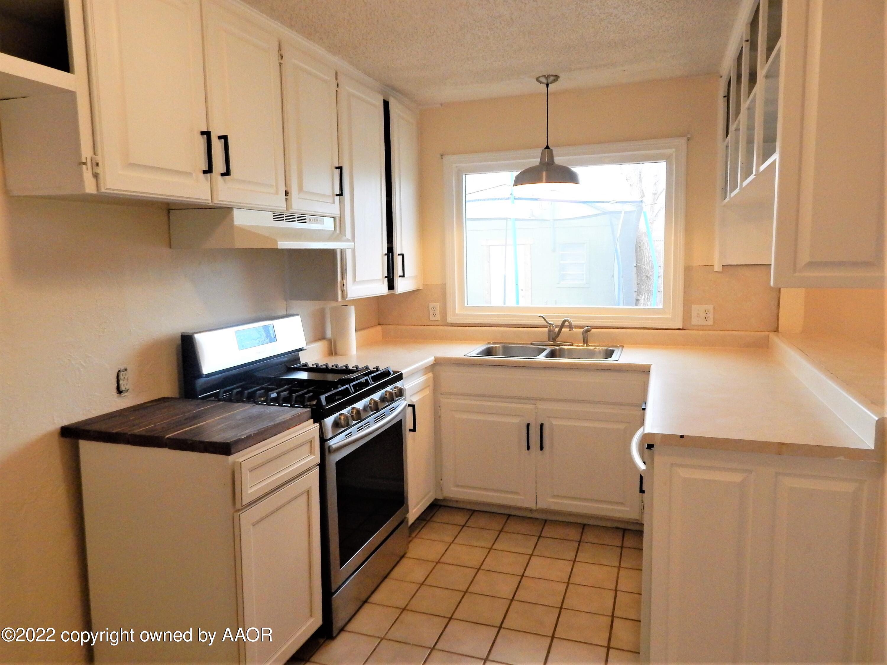 4202 South Lipscomb Street Amarillo, TX 79110 - Photo 11 of 25 a kitchen with a stove sink and cabinets