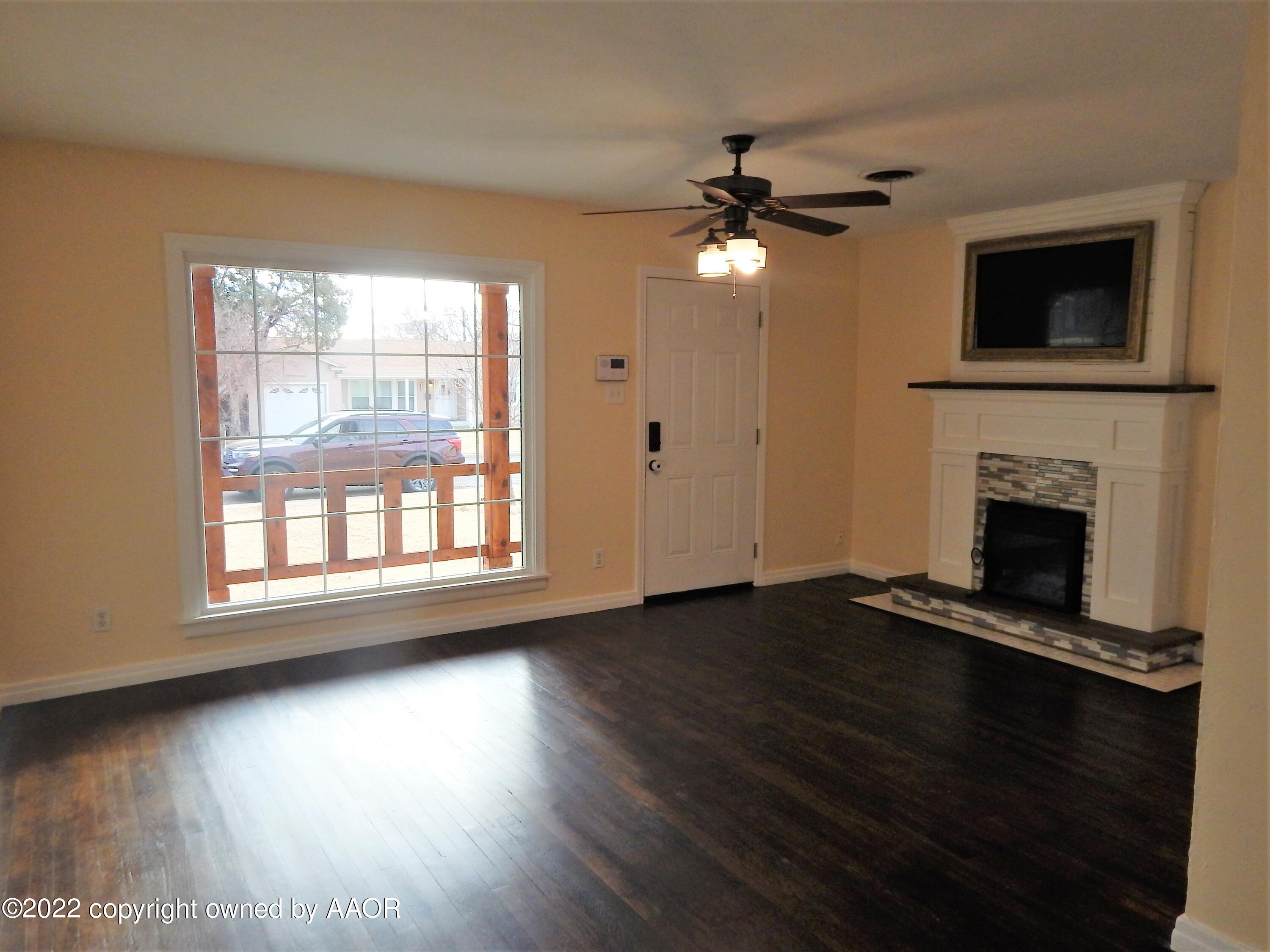 4202 South Lipscomb Street Amarillo, TX 79110 - Photo 5 of 25 a view of empty room with wooden floor fireplace and a window