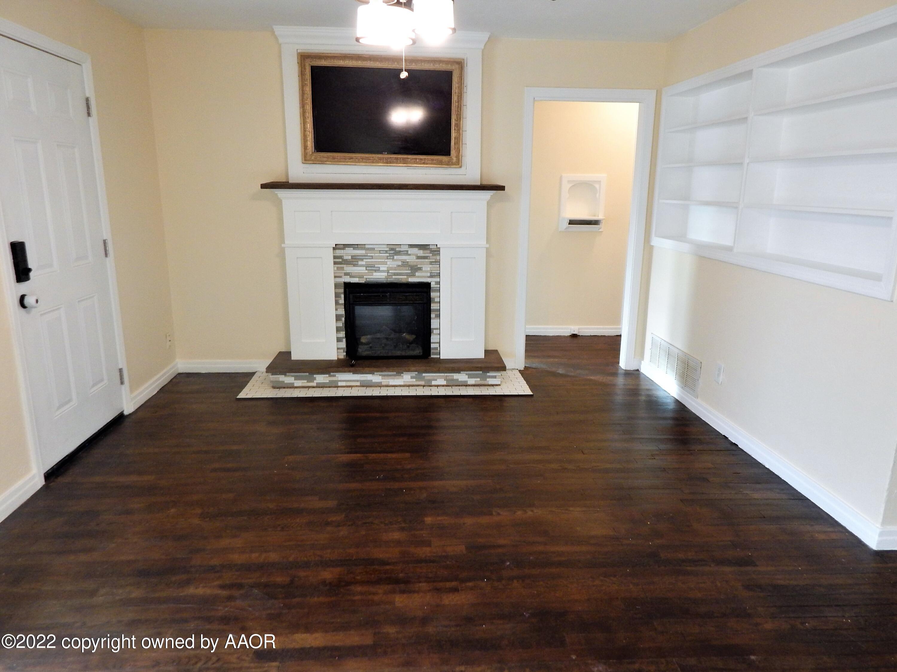 4202 South Lipscomb Street Amarillo, TX 79110 - Photo 6 of 25 a view of an empty room with wooden floor and a fireplace