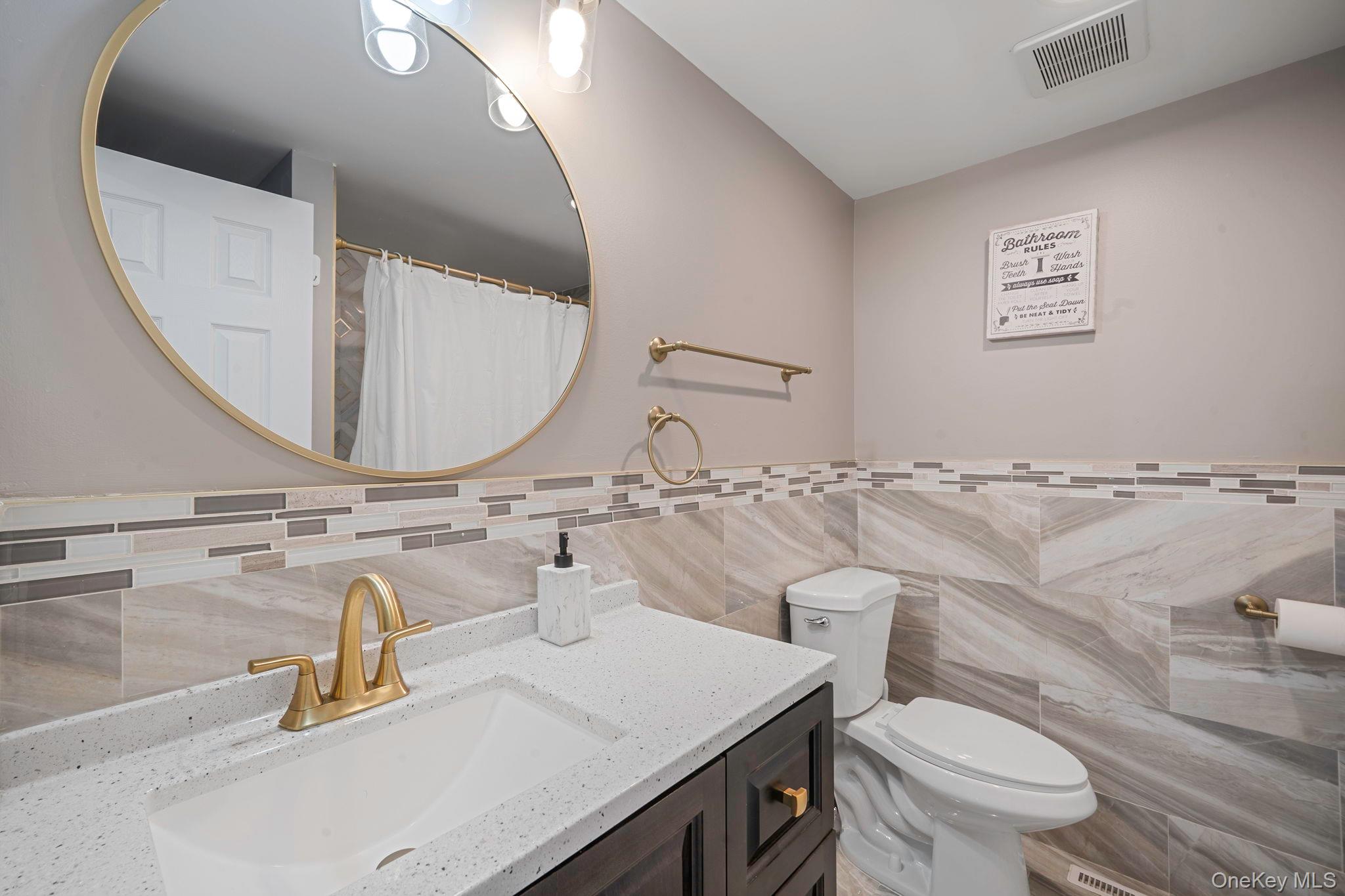 232 30th Street Lindenhurst, NY 11757 - Photo 12 of 46 a bathroom with a toilet sink and mirror