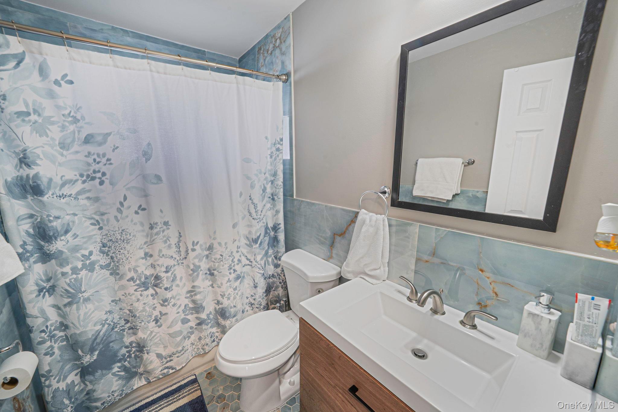 232 30th Street Lindenhurst, NY 11757 - Photo 16 of 46 a bathroom with a sink toilet and mirror