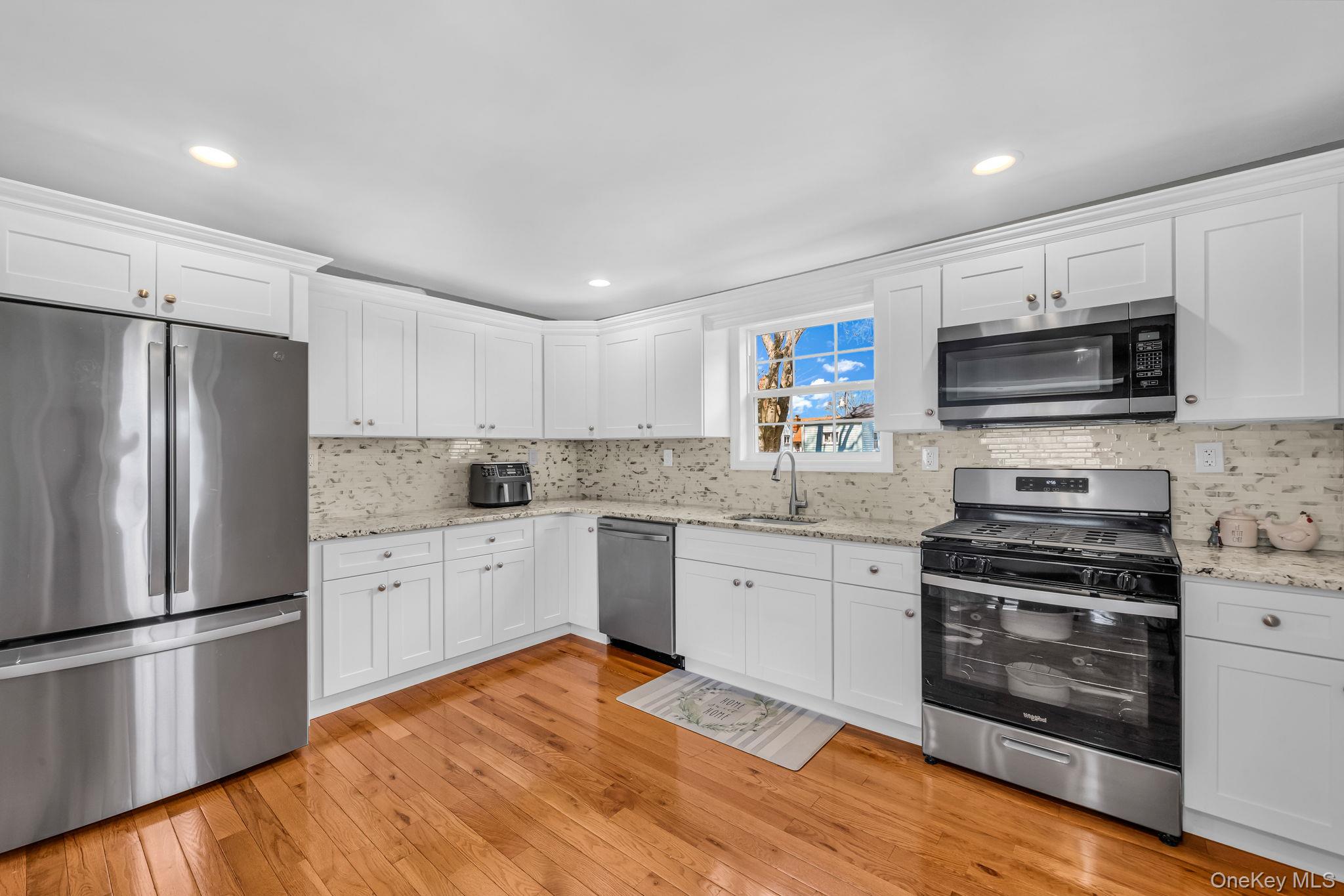 232 30th Street Lindenhurst, NY 11757 - Photo 17 of 46 a kitchen with granite countertop a refrigerator stove and microwave