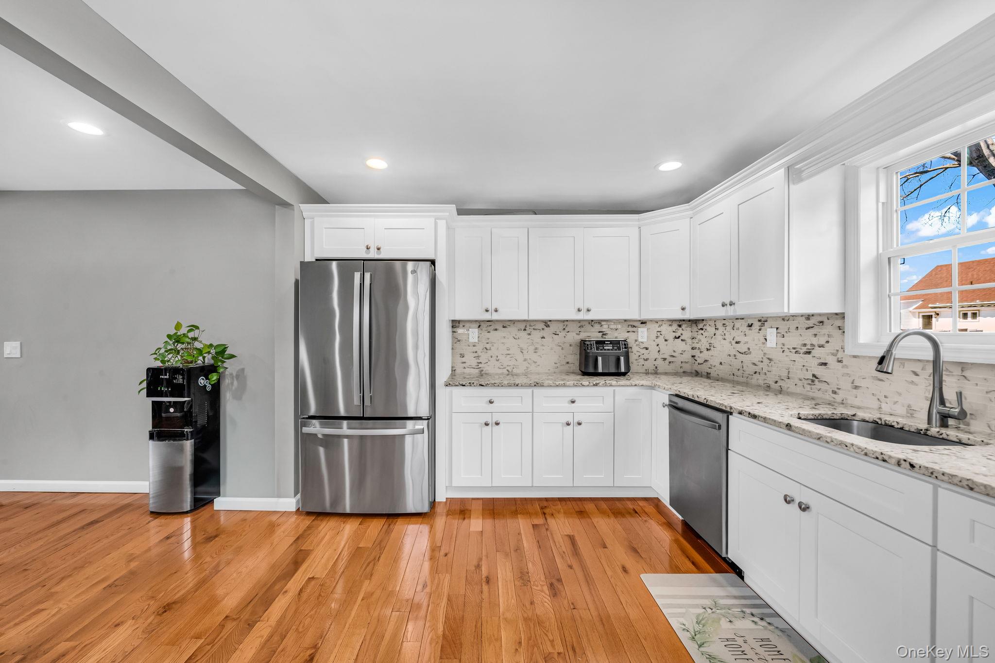 232 30th Street Lindenhurst, NY 11757 - Photo 19 of 46 a kitchen with granite countertop stainless steel appliances a refrigerator and sink