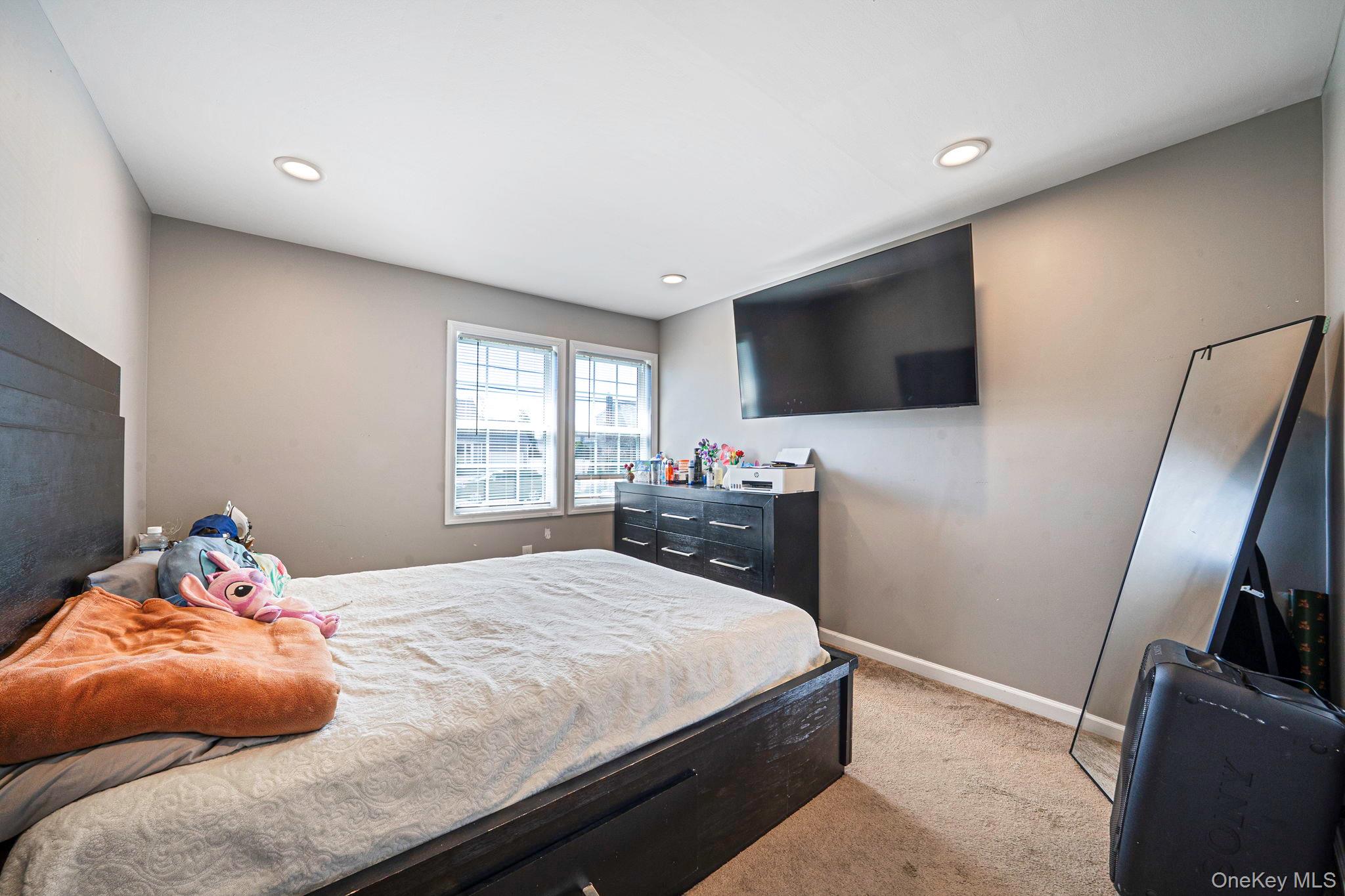 232 30th Street Lindenhurst, NY 11757 - Photo 28 of 46 a bedroom with a bed and a flat screen tv