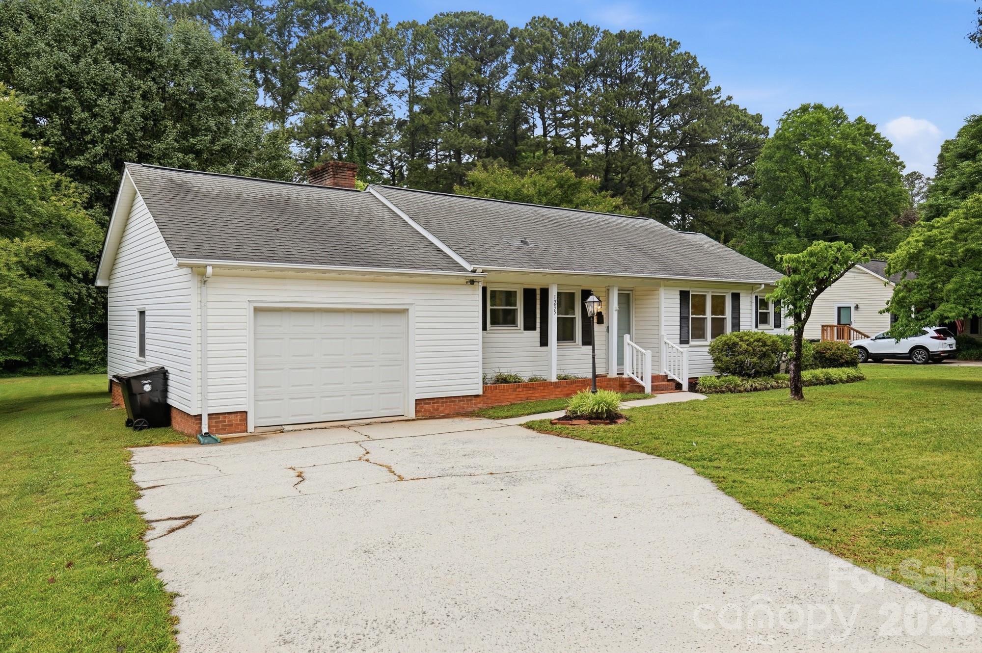 1235 Winecoff School Road Concord, NC 28027 - Photo 2 of 27 a view of a white house with a big yard and large trees