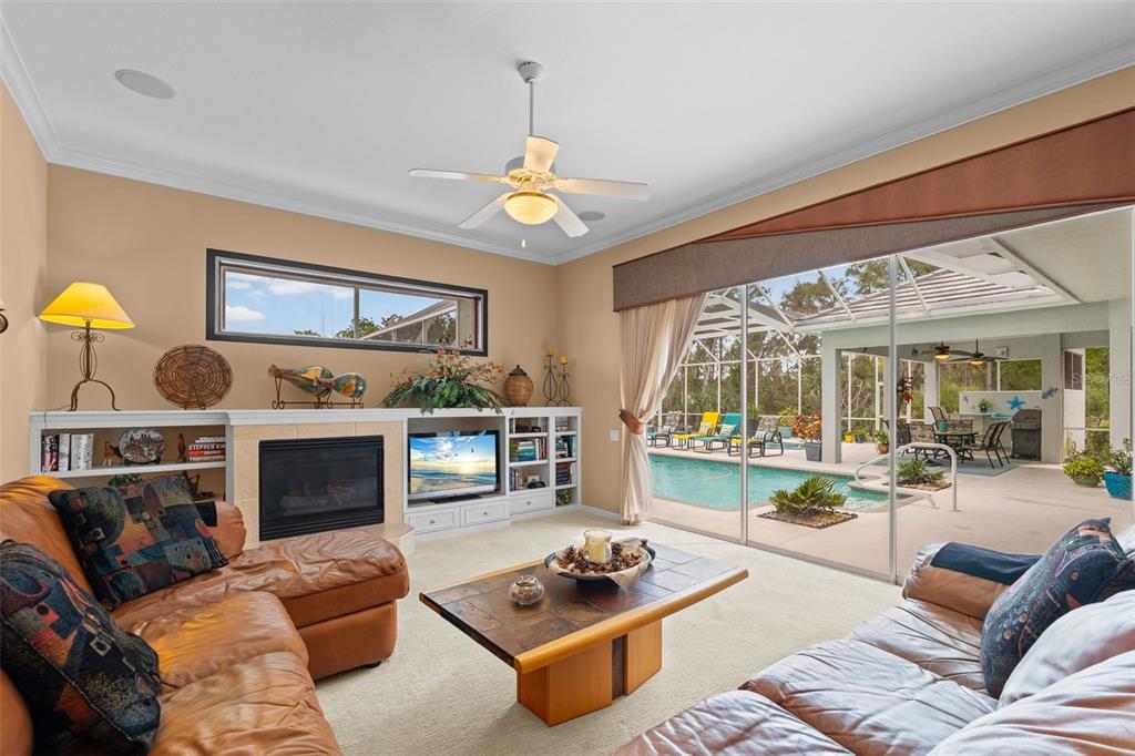 7517 Coventry Court Lakewood Ranch, FL 34202 - Photo 29 of 96 a living room with furniture a fireplace and a chandelier