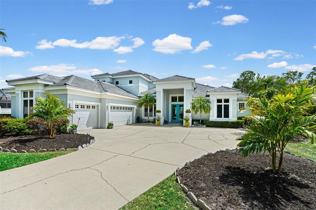 7517 Coventry Court Lakewood Ranch, FL 34202 - Photo 96 of 96 a view of a white house with a yard and potted plants