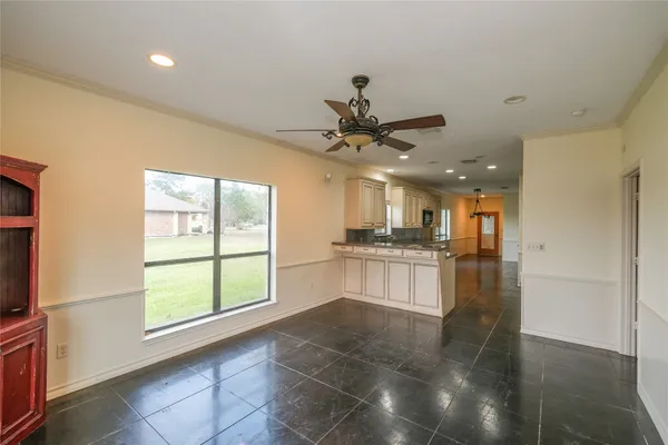 a kitchen with kitchen island granite countertop a refrigerator a sink a stove and white cabinets