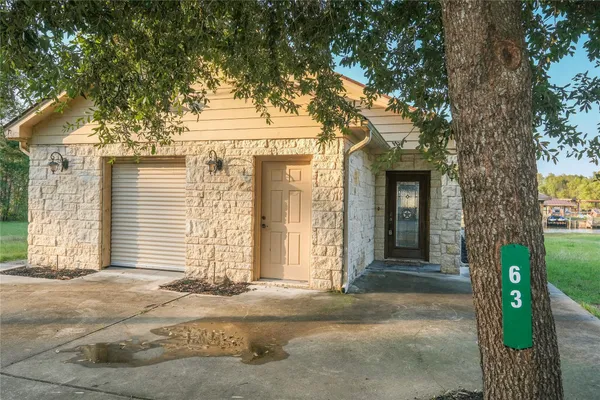 a front view of a house with a tree
