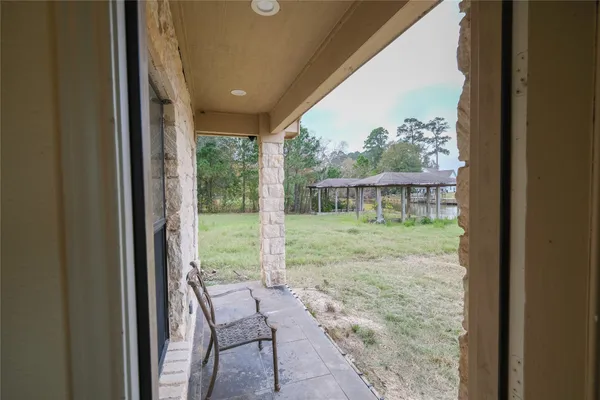 a view of a porch with furniture and garden