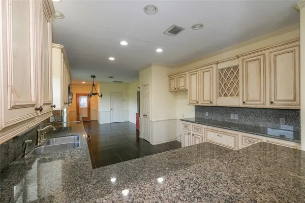 a large kitchen with stainless steel appliances granite countertop a large counter top and a stove