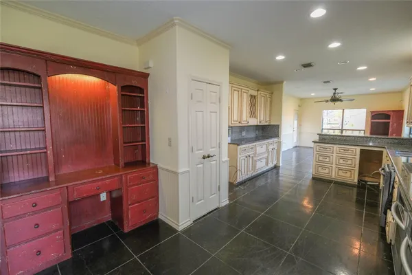 a kitchen with granite countertop a refrigerator and a stove top oven