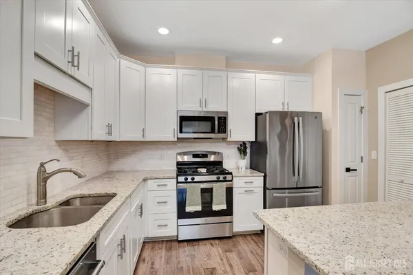 a kitchen with stainless steel appliances granite countertop a refrigerator sink and stove