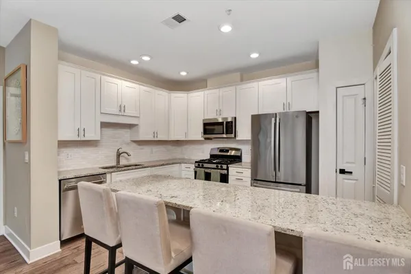 a kitchen with kitchen island a refrigerator stove microwave and cabinets