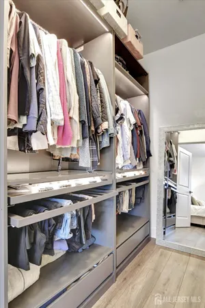 a view of walk in closet with clothes and shoes