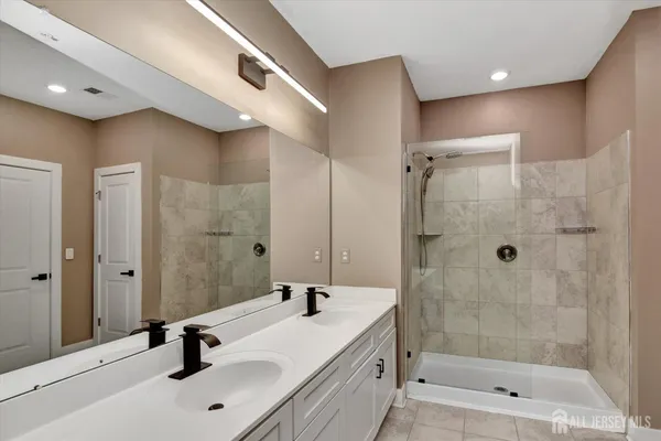 a bathroom with a shower a sink and a mirror