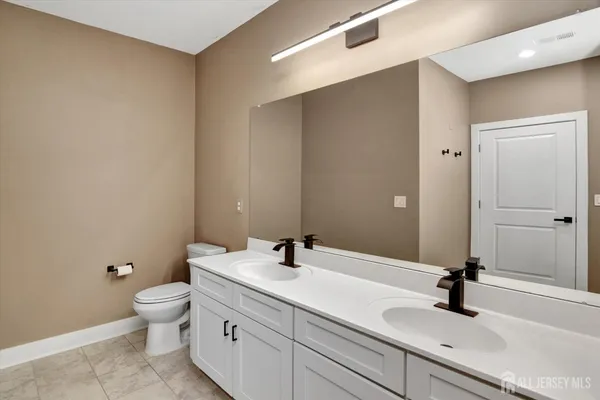 a bathroom with a sink a toilet and a mirror