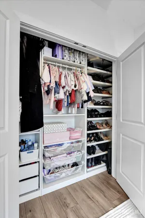 a view of walk in closet with clothes and shoes