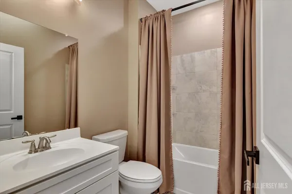 a bathroom with a sink a toilet a mirror and shower