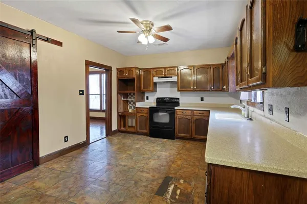 a kitchen with kitchen island a counter top space cabinets and stainless steel appliances