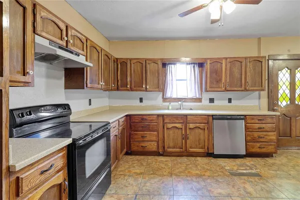 a kitchen with stainless steel appliances granite countertop a stove a sink and a microwave