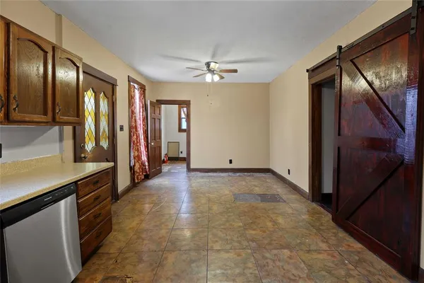 a view of a hallway with stainless steel appliances granite countertop cabinets and a counter top space