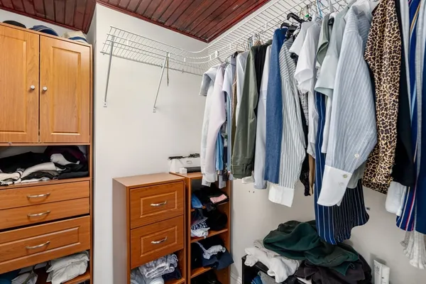 a view of walk in closet with clothes and shoes