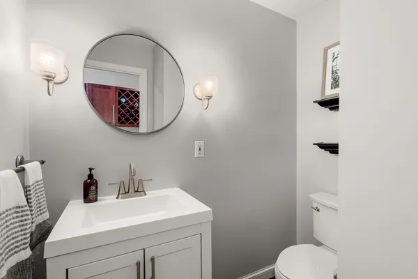 a bathroom with a toilet a sink and mirror