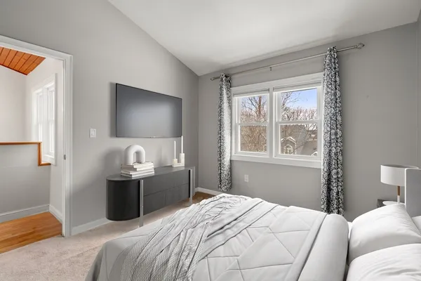 a bedroom with a bed and a flat tv screen on the dresser