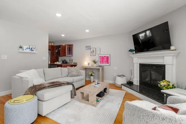 a living room with furniture a flat screen tv and a fireplace