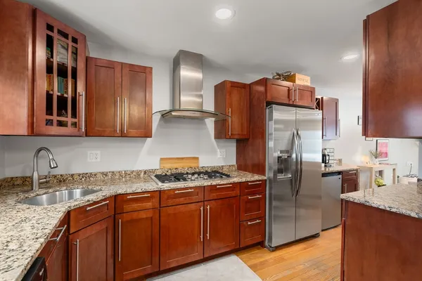 a kitchen with stainless steel appliances granite countertop a sink stove and refrigerator