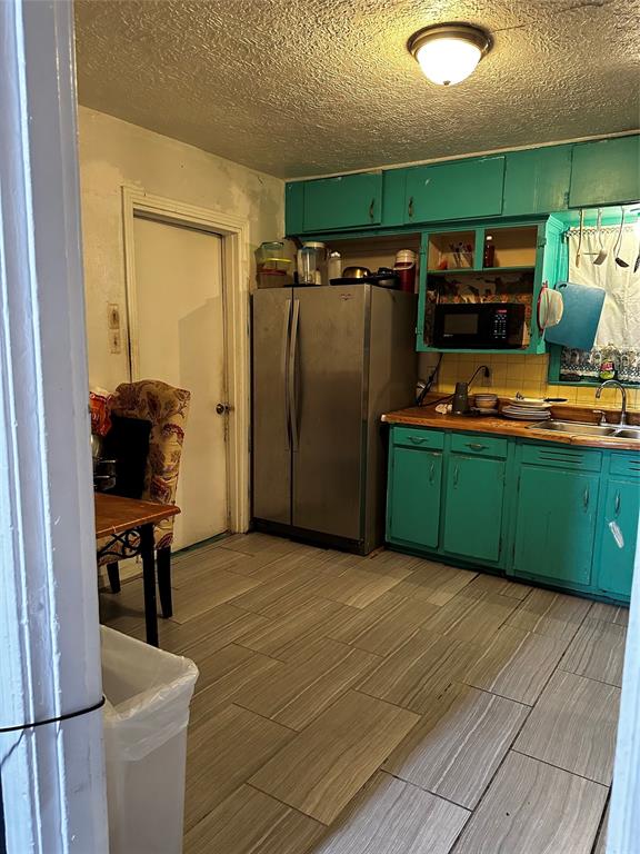 a view of a kitchen with a sink and a refrigerator